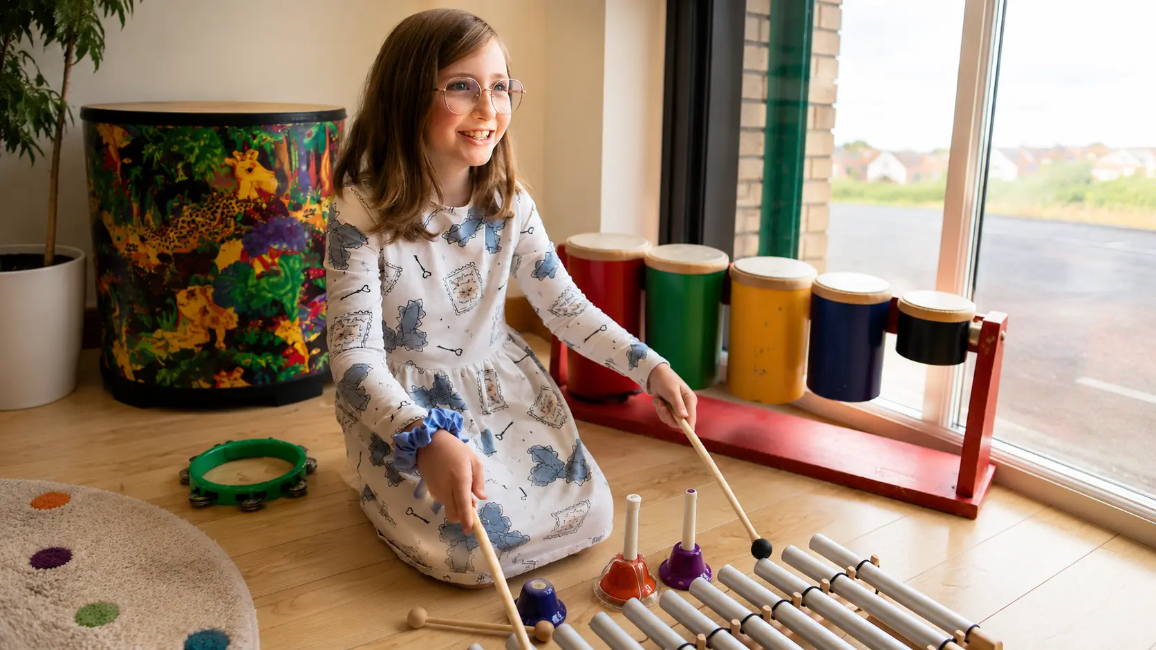 Music therapy session with a young girl playing a musical instrument